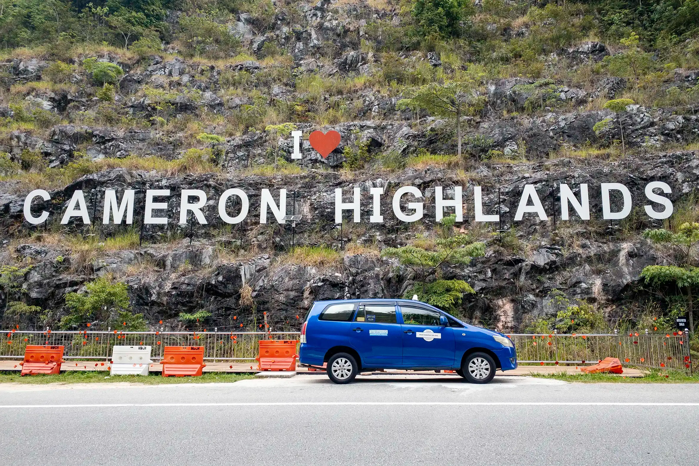 My Little Taxi Toyota Innova in Cameron Highlands Blue My Little Taxi Toyota Innova parked below the I Love Cameron Highlands hillside sign.