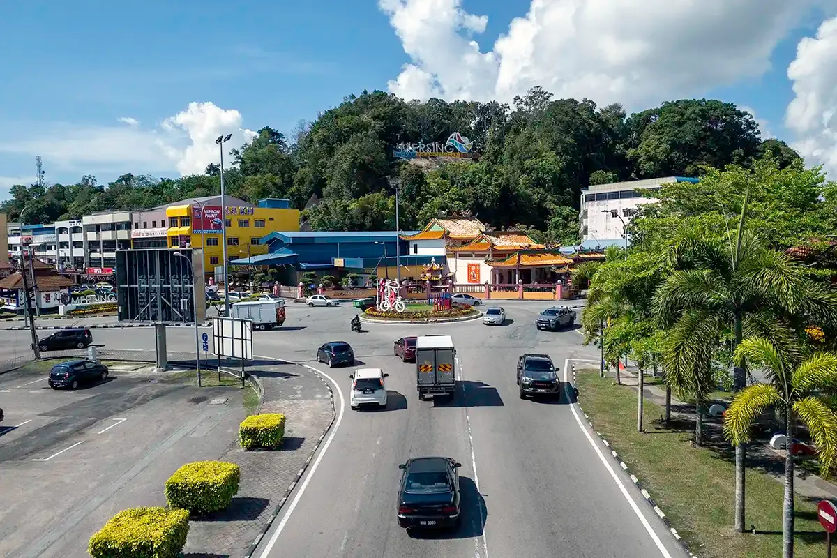 Street scene in Mersing town with shops, traffic and surrounding greenery