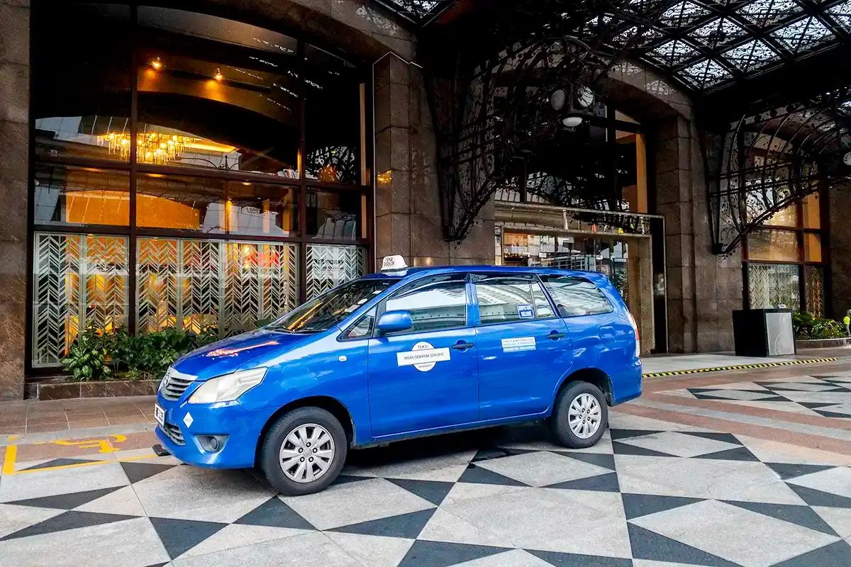 My Little Taxi Toyota Innova waiting outside a Kuala Lumpur hotel for a private day-trip pickup