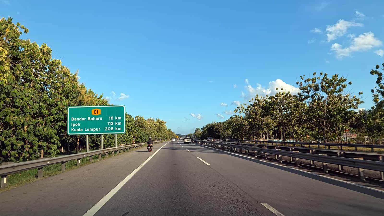 Malaysia highway with clear blue sky for private intercity transfers from Kuala Lumpur